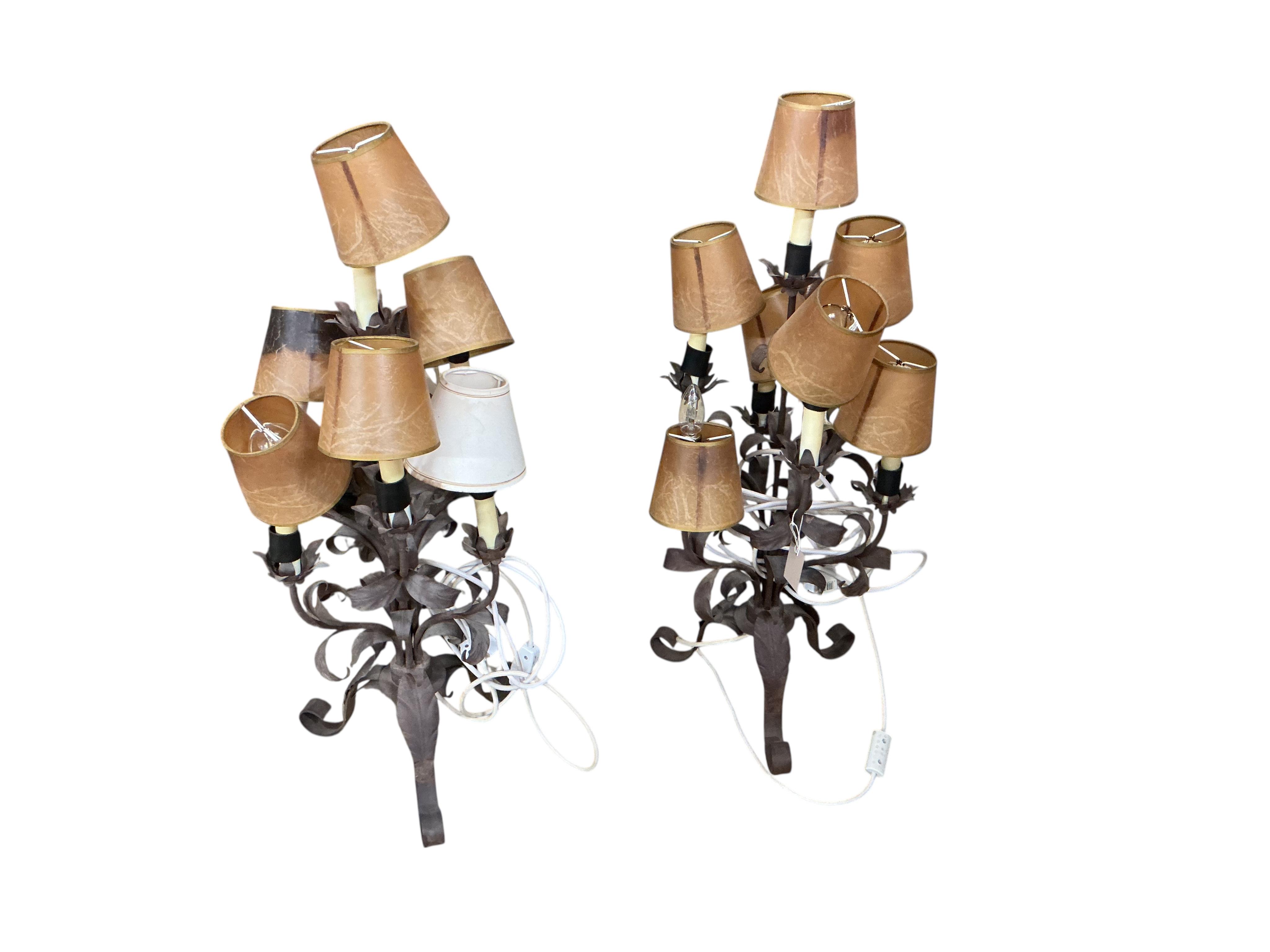 A pair of wrought and embossed four branch, five light candelabra, height 94cm